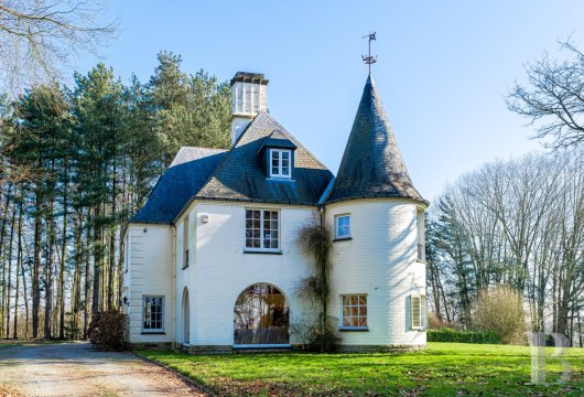 Facing the Rigenée golf course, a 1963 mansion with a conical tower, its outbuildings and 1.7 ha of wooded parkland.