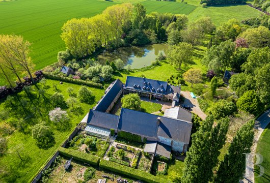In Longueville, a red brick farm-castle, its outbuildings and its 7 ha estate with ponds