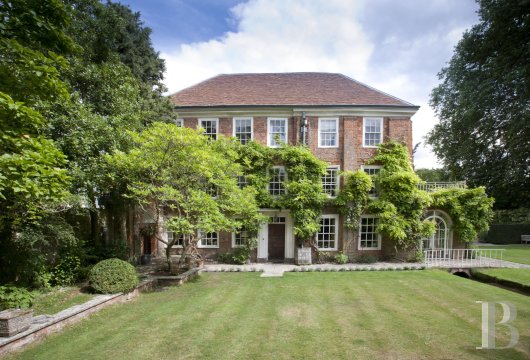 In Winchester, Hampshire, on the site of a former monastery, a historic red brick residence and its outbuilding ...