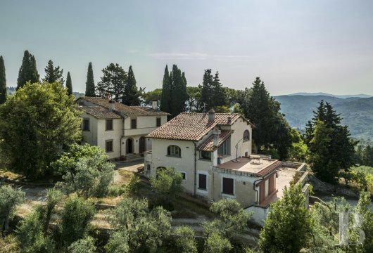 Overlooking Florence from a sunny hilltop, a villa with outbuildings on an 8-hectare estate