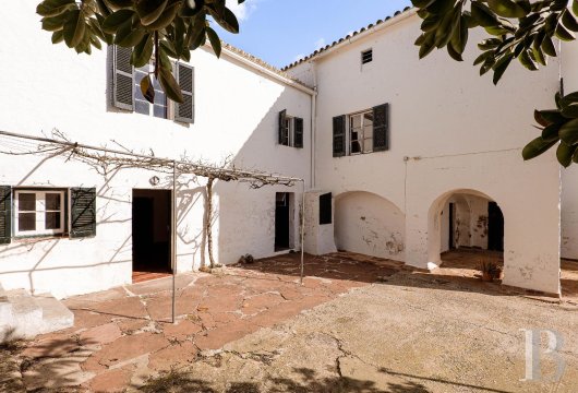 In the Menorca countryside, a historic finca and its private chapel, set on 135 hectares of farmland with nearly ...