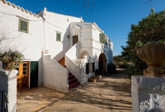 In the Menorcan countryside, on the outskirts of Ciutadella, an old farmhouse with stone arches and a separate ...